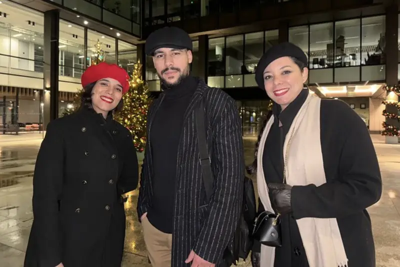 Three guests in winter coats on a night tour