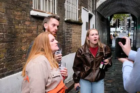 Guests reacting to a story in a narrow alley
