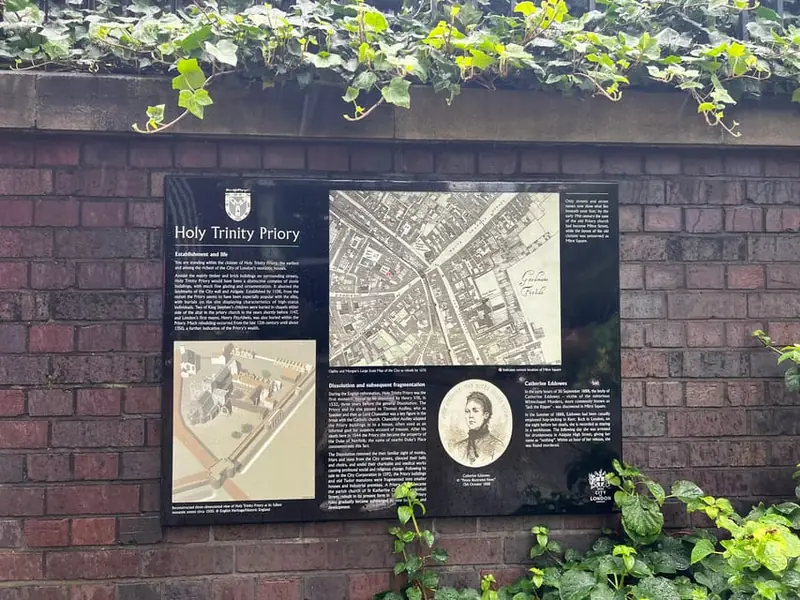 A history plaque about Holy Trinity Priory on a brick wall